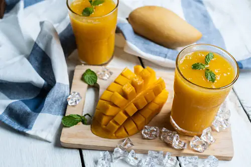 Refreshing and healthy mango smoothie in a glass with mango